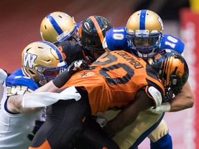 Winnipeg Blue Bombers’ Nic Demski (right) is hit by B.C. Lions’ Bo Lokombo during their game at B.C. Place in Vancouver last night. (The Canadian Press)
