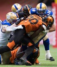 Winnipeg Blue Bombers’ Nic Demski (right) is hit by B.C. Lions’ Bo Lokombo during their game at B.C. Place in Vancouver last night. (The Canadian Press)