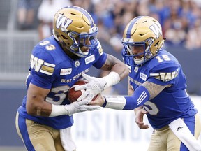 Winnipeg Blue Bombers quarterback Matt Nichols (15) hands off to Andrew Harris (33) during the first half of CFL action against the BC Lions in Winnipeg Saturday, July 7, 2018. THE CANADIAN PRESS/John Woods ORG XMIT: JGW101