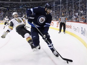Vegas Golden Knights' Colin Miller (6) loses the fight for the puck against Winnipeg Jets' Adam Lowry (17) during second period NHL action in Winnipeg on February 1, 2018. The Winnipeg Jets have avoided salary arbitration with forward Adam Lowry, signing him to a three-year, US$8.75 million contract. The 25-year-old played in 45 games for the Jets last season, recording 21 points (eight goals, 13 assists) and eight penalty minutes. THE CANADIAN PRESS/John Woods ORG XMIT: CPT129