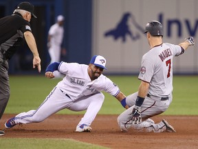 Joe Mauer of the Minnesota Twins slides safely into second base on a two-base error in the sixth inning as Devon Travis of the Toronto Blue Jays attempts to make the tag at Rogers Centre on July 24, 2018 in Toronto. (Tom Szczerbowski/Getty Images)