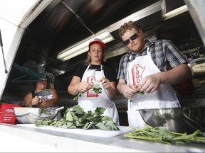 Sarah Story, project coordinator at Manitoba Food History Project (MFHP) and Kent Davies, collaborator in MFHP interview Anna Sigrithur, centre, producer of the Ox Tales podcast for Oxford Food Symposium, as she cooks up some crepes inside the MFHP food truck at the Mennonite Heritage Village in Steinbach.