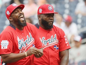 Vladimir Guerrero (left) and manager David Ortiz of the World Team share a laugh at the MLB Futures Game at Nationals Park in Washington, D.C. yesterday. (Getty images)