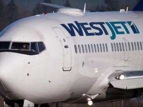 A pilot taxis a Westjet Boeing 737-700 plane to a gate after arriving at Vancouver International Airport in Richmond, B.C., on February 3, 2014. (The Canadian Press/Darryl Dyck)