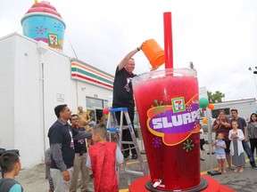 Vice President and General Manager of 7-Eleven Canada Doug Rosencrans pours the last bit of Slurpee to fill the world's largest Slurpee cup (711 litres) during 7-Eleven Day festivities to mark Manitoba being crowned Slurpee Capital of the World for the 18th consecutive year on Tuesday, July 11, 2017, at the 7-Eleven on Salter Street in Winnipeg.