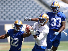 Adarius Bowman (centre) battles for possession of a pass with Chandler Fenner (left) and Brandon Alexander during Winnipeg Blue Bombers practice last week. The Bombers closed Tuesday's practice to the public and the media.
