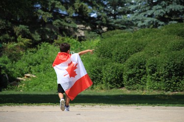 A young boy wrapped in a Canadian flag celebrates Canada Day 151 at The Forks in Winnipeg on Sunday, July 1, 2018