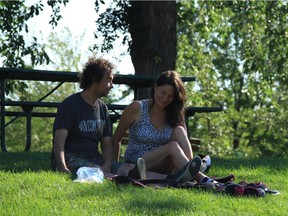Wayne Ducharme and Crystal Gould enjoy a spot of shade in Assiniboine Park on Friday. Winnipeg has been put under a heat warning with weekend temperatures expected to reach 35 C, nearly 10 degrees above the average temperature according to Environment Canada.