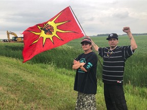 Dakota organizer Geraldine McManus and Shaun Laqueppe of the Turtle Island Awareness group hold the flag near the Spirit of the Buffalo Camp on Border Road east of Gretna.