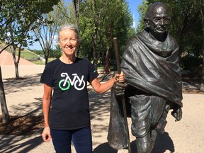 Guinness World Record holder Lynn Salvo, 68, from McLean, Va., stands by the statue of Indian leader and peace activist Mahatma Gandhi at the Canadian Museum for Human Rights in Winnipeg on Sunday, July 15, 2018. Salvo stopped in Winnipeg on Sunday as part of a 6,400-kilometre cycling across Canada for world peace. Salvo set her first Guinness World Record in 2016 by cycling 3,163 miles or 5,000 kilometres ocean-to-ocean in the U.S., and is out to become the oldest woman to cycle across Canada.