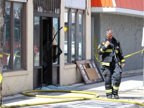 A firefighter communicates with others in the aftermath of a fire in the 400 block of Selkirk Avenue between Powers and Salter streets in Winnipeg on July 16. Two teenagers have been charged with arson and other offences in the incident.