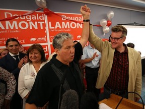 Liberal leader Dougald Lamont (right) has his hand raised by Liberal MP Dan Vandal at the Norwood Hotel in Winnipeg after winning the St. Boniface by-election on Tues., July 17, 2018. Kevin King/Winnipeg Sun/Postmedia Network