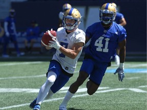 Weston Dressler (left) pulls down a pass with Abubakarr Conteh in pursuit during Winnipeg Blue Bombers practice.