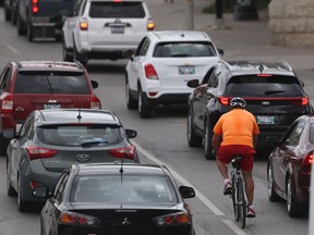 A cyclist in traffic in Winnipeg.  Tuesday , July/ 24/2018 Winnipeg Sun/Chris Procaylo/stf