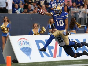 Blue Bombers SB Nic Demski extends the ball across the goal line for a touchdown with Argonauts LB Akeem Jordan in tow on Friday night. Kevin King/Winnipeg Sun/Postmedia Network