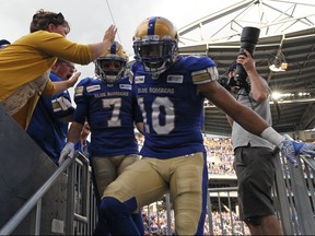 Winnipeg Blue Bombers slotbacks Nic Demski (right) and Weston Dressler come out of the stands after celebrating a touchdown catch from Demski against the Toronto Argonauts on Friday.