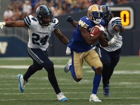 Blue Bombers receiver Kenbrell Thompkins runs after a catch with Argonauts’ Justin Tuggle (left) and LB Marcus Ball in pursuit last night.  Kevin King/Winnipeg Sun