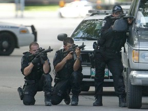 Members of the Winnipeg Police tactical support unit maintain a position in front of a house during a standoff. Police response times are suffering due to a lack of resources, higher reporting rates and the meth crisis says the police association.