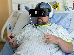 Patient Graydon Cuthbertson wears a Samsung Gear virtual reality headset while having his wounds treated at the Rockyview Hospital in Calgary, on Thursday August 30, 2018.