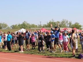 Athletes, supporters and event volunteers warm up before the Turning Leaf Games at the University of Manitoba's track and field stadium on Wednesday, Aug. 15, 2018. (JOYANNE PURSAGA/Winnipeg Sun/Postmedia Network)