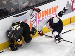 In this May 30 file photo, Washington Capitals defenceman John Carlson (right) checks Vegas Golden Knights forward James Neal into the boards during Game 2 of the Stanley Cup final.