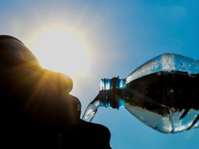 A man poses while drinking from a water bottle as the sun shines in the northern French city of Lille on July 25, 2018.   Some 18 departments across France have been placed on an 'orange' alert as heatwave conditions prevail across western Europe. / AFP PHOTO / DENIS CHARLETDENIS CHARLET/AFP/Getty Images