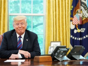 U.S. President Donald Trump listens during a phone conversation with Mexico's President Enrique Pena Nieto on trade in the Oval Office of the White House in Washington, DC on Monday. Trump said the U.S. had reached a "really good deal" with Mexico and talks with Canada would begin shortly on a new regional free trade pact."It's a big day for trade. It's a really good deal for both countries," Trump said."Canada, we will start negotiations shortly. I'll be calling their prime minister very soon," Trump said. (MANDEL NGAN / AFP)