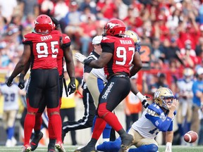 Calgary Stampeders Micah Johnson celebrates with teammates Ja'Gared Davis and Derek Wiggan after a sack quarterback Matt Nichols of the Winnipeg Blue Bombers during CFL football in Calgary on Saturday, August 25, 2018. Al Charest/Postmedia