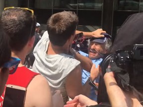 Sun photographer Stan Behal is attacked during an anti-racism protest at Nathan Phillips Square on Saturday, Aug. 11.