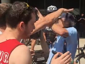 A protester attacks Toronto Sun photographer Stan Behal at a rally Saturday, Aug. 11, 2018 at Nathan Phillips Square.