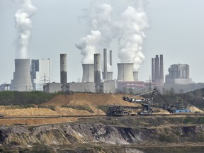 In this April 3, 2014 file photo giant machines dig for brown coal at the open-cast mining Garzweiler in front of a power plant near the city of Grevenbroich in western Germany. (AP Photo/Martin Meissner, File)
