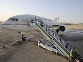 Passengers disembark from a plane belonging to Saudia airline, at Baghdad International Airport, in Iraq, Thursday, Oct. 19, 2017. The rift between the federal government and Saudi Arabia has prompted the country's state airline to suspend operations in Canada.