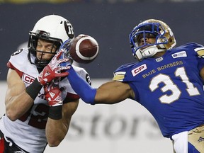 Winnipeg Blue Bombers' Maurice Leggett (31) intercepts the pass intended for Ottawa Redblacks' Greg Ellingson (82) during the second half of CFL action in Winnipeg Friday, September 22, 2017. THE CANADIAN PRESS/John Woods ORG XMIT: JGW115