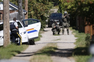 The RCMP emergency response unit moves in on a home in Neepawa, Man., on Thursday, August 30, 2018 as they search for an alleged suspect in the shooting of a RCMP officer in Onanole, Man. THE CANADIAN PRESS/John Woods