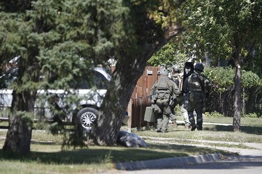 The RCMP emergency response unit moves in on a home in Neepawa, Man., on Thursday, August 30, 2018 as they search for an alleged suspect in the shooting of a RCMP officer in Onanole, Man. THE CANADIAN PRESS/John Woods