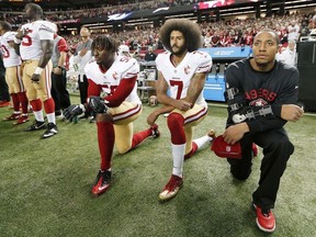 In this Dec. 18, 2016, file photo, San Francisco 49ers quarterback Colin Kaepernick (7) and outside linebacker Eli Harold (58) kneel during the playing of the national anthem before an NFL football game against the Atlanta Falcons in Atlanta.