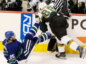 Canucks Josh Green (25) is hit hard by Dallas Stars Eric Lindros (88) during the first period of game seven in the first round of the NHL Stanley Cup playoffs at GM Place Stadium in Vancouver April 23, 2007.