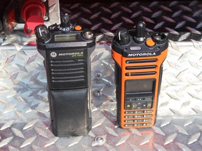 The province's new two-way radios for emergency service providers are displayed during a press conference at the West St. Paul Fire hall on Wednesday, Aug. 8, 2018. The new orange model at right, will replace the current black one (left) and be paired with a beefed up network for communications, beginning in 2021. (JOYANNE PURSAGA/Winnipeg Sun/Postmedia Network)