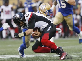 Ottawa quarterback Trevor Harris fumbles the ball after getting hit by Blue Bombers’ Kevin Fogg last night. The Canadian Press