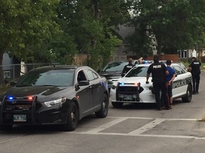 Winnipeg police take a man into custody on the corner of Bruce Avenue and Winchester Street on Saturday, after he was chased on his bicycle by a police cruiser down residential streets. He faces numerous charges including assault on a police officer and resisting arrest.