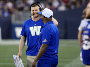 Winnipeg Blue Bombers head coach Mike O'Shea (left) shares a laugh on the sideline with defensive backs coach Jordan Younger during CFL action against the Toronto Argonauts in Winnipeg on Fri., July 27, 2018. Kevin King/Winnipeg Sun/Postmedia Network