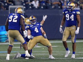 Winnipeg Blue Bombers LB Adam Bighill (4) celebrates with teammates after sacking Hamilton Tiger-Cats QB Jeremiah Masoli to ensure victory during CFL action in Winnipeg on Fri., Aug. 10, 2018. Kevin King/Winnipeg Sun/Postmedia Network