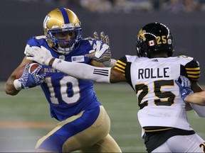 Winnipeg Blue Bombers SB Nic Demski (left) evades Hamilton Tiger-Cats LB Jumal Rolle during CFL action in Winnipeg on Friday.