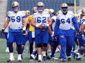 Suspended offensive lineman Qadr Spooner (right) works out with teammates during Winnipeg Blue Bombers practice on Monday.