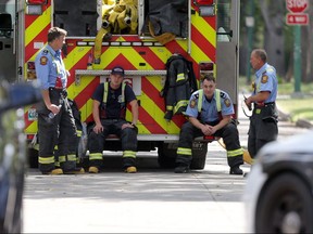 Firefighters sitting around at a fire scene in Winnipeg. .   Tuesday, August 21/2018 Winnipeg Sun/Chris Procaylo/stf