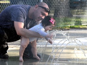 Jihad Hamza and his daughter Eeva, seven months, enjoy the warm weather on Sat., Sept. 15, 2012, at the spray pad at Vimy Ridge Park.