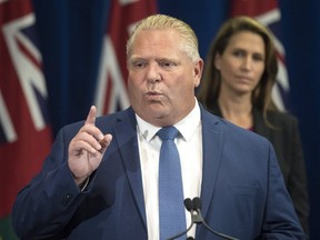 Ontario Premier Doug Ford answers questions from journalists as Ontario Attorney General Caroline Mulroney looks on during a press announcement at the Queens Park Legislature in Toronto on Aug. 9, 2018. THE CANADIAN PRESS