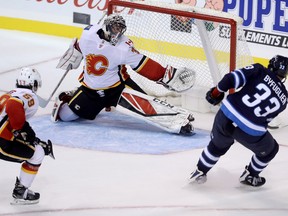 Jets’ Dustin Byfuglien (right), scores the game-winner in overtime on Calgary Flames goaltender Jeff Glass during 
pre-season action on Friday night
in Winnipeg. (THE CANADIAN PRESS)