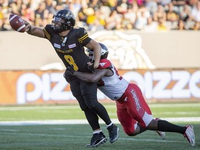 Hamilton Tiger-Cats quarterback Jeremiah Masoli (8) tries to get rid of the ball to avoid a sack by Calgary Stampeders defensive lineman Ja'Gared Davis (95) during second half CFL Football game action in Hamilton, Ontario on Saturday, September 15, 2018.