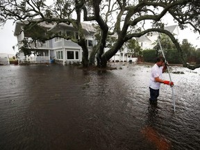 Mike Pollack searches for a drain in the yard of his flooded waterfront home a day after Hurricane Florence hit the area, on Sept. 15, 2018 in Wilmington, N.C.